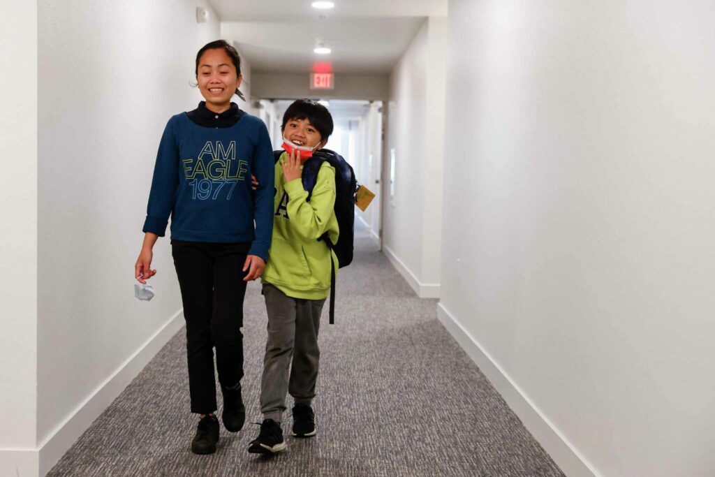 Family walk side-by-side in a hallway—symbolizing trust and routine.