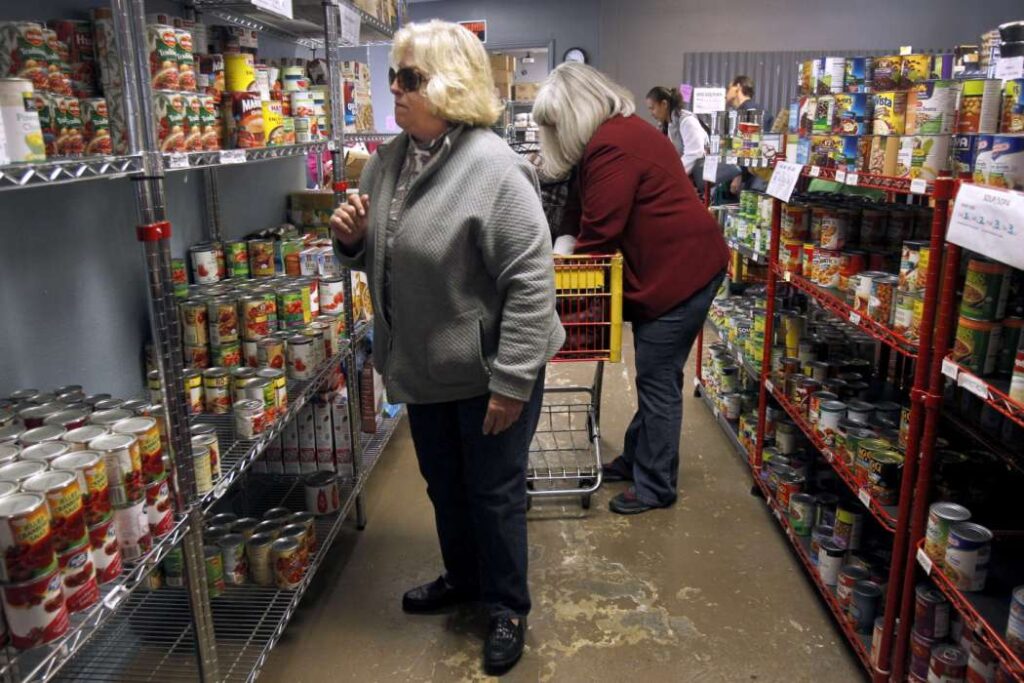 Two women browse shelves at food pantry.