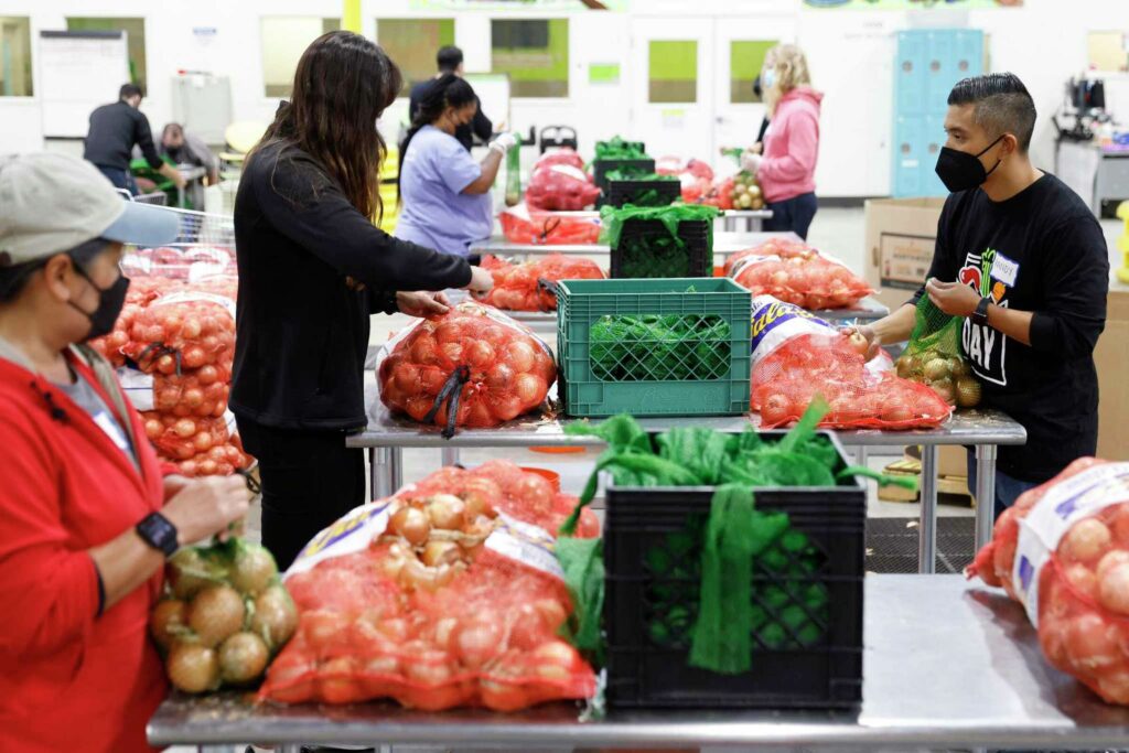 Volunteers organize onions and vegetables at a food bank—capturing generosity and teamwork.