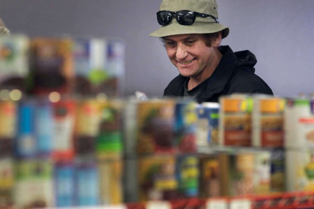 Man browses canned goods at food pantry.