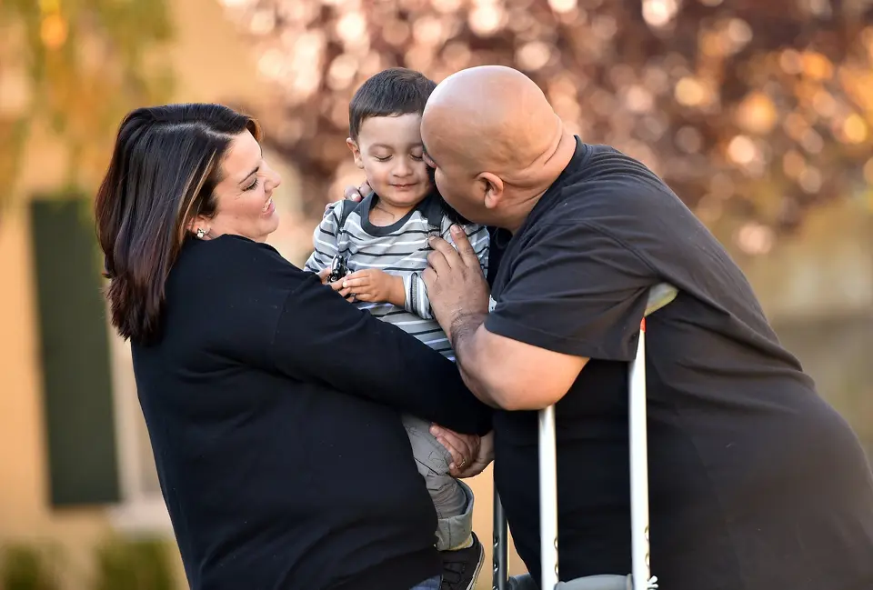 Family embracing each other for photo outdoors.