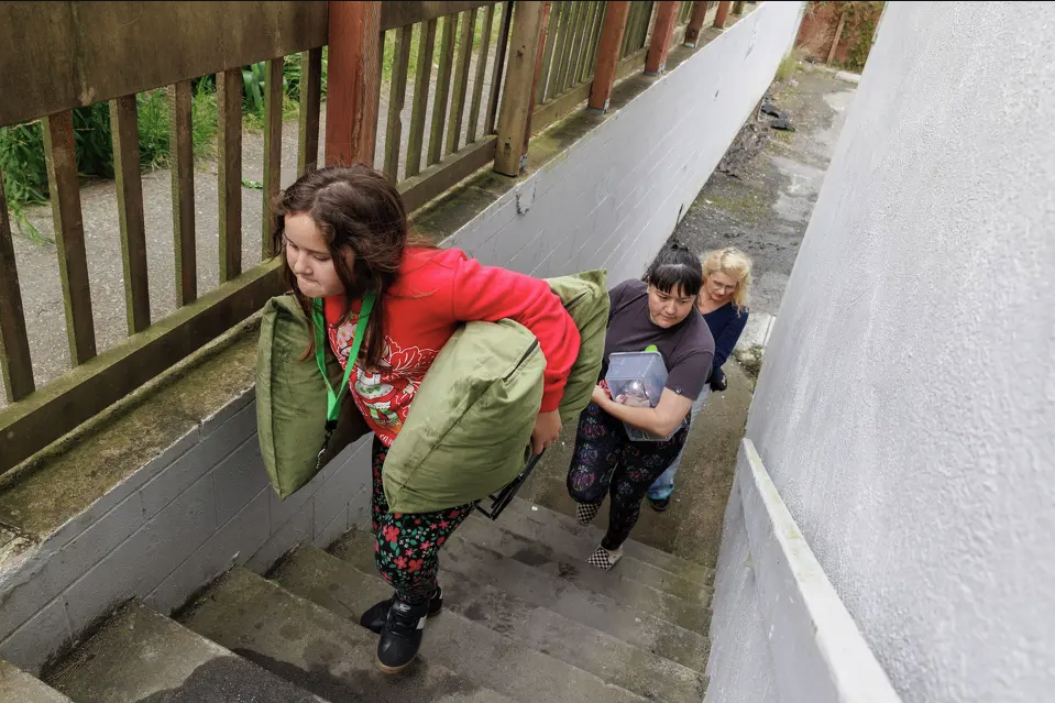 Family walks up stairs moving into new apartment
