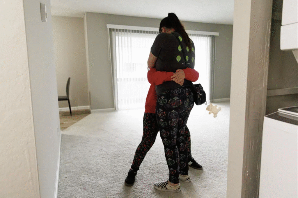 Mother hugs child in new apartment.